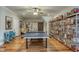 Well-lit game room with hardwood floors, ping pong table, and rustic sliding door at 633 Rolling Springs Dr, Cary, NC 27519