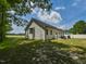 Exterior view of the backyard featuring a patio, privacy fence, lush grass, and beautiful trees at 710 Country Rd, Middlesex, NC 27557