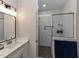 Bright bathroom with dual sinks, quartz countertops, modern vanity, and glass shower at 710 Country Rd, Middlesex, NC 27557