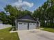 View of home's three-car garage with white doors and dark gray trim at 710 Country Rd, Middlesex, NC 27557