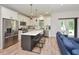 Well-lit kitchen featuring an island with bar seating, stainless steel appliances, and direct access to the living room at 710 Country Rd, Middlesex, NC 27557