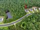 Beautiful aerial view of the home nestled among trees with a pond nearby at 720 The Parks Dr, Pittsboro, NC 27312