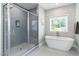 Bathroom featuring a glass shower, a soaking tub with an adjacent window, and modern fixtures at 720 The Parks Dr, Pittsboro, NC 27312