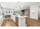 Bright open-concept kitchen with quartz countertops, stainless steel appliances, and eat-in island at 720 The Parks Dr, Pittsboro, NC 27312