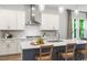 Spacious kitchen with a large island, sleek range hood, and stylish bar stool seating at 720 The Parks Dr, Pittsboro, NC 27312