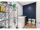Well-organized laundry room with washer, dryer, shelving, and decorative wallpaper at 720 The Parks Dr, Pittsboro, NC 27312