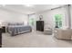 Serene bedroom features neutral tones, comfortable chairs, and plenty of natural light from windows at 720 The Parks Dr, Pittsboro, NC 27312