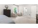 Bright bedroom with accent chairs, a dark wood dresser and large windows at 720 The Parks Dr, Pittsboro, NC 27312