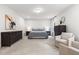 Bright main bedroom with a large bed, dresser, carpet and accent chairs at 720 The Parks Dr, Pittsboro, NC 27312