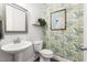 Stylish powder room with modern fixtures, decorative wallpaper, and leafy foliage accents at 720 The Parks Dr, Pittsboro, NC 27312