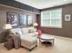 Comfortable living room has a sectional sofa, movie posters and carpet flooring at 7502 Hedfield Way, Durham, NC 27713