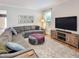 Cozy living room features a large sectional sofa, neutral tones, and lots of natural light at 7502 Hedfield Way, Durham, NC 27713