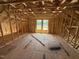 Spacious bedroom showing exposed rafters, unfinished plywood floor and two windows at 76 Tuskeegee Dr, Smithfield, NC 27577