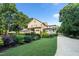 Landscaped backyard with lush lawn, mature trees, and well-maintained garden beds at 7713 Summercrest Dr, Apex, NC 27539