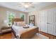 Serene bedroom with natural light, a wicker bed frame, neutral tones, and hardwood floors at 7713 Summercrest Dr, Apex, NC 27539
