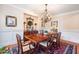 Formal dining room with a chandelier, wainscoting, and hardwood floors at 7713 Summercrest Dr, Apex, NC 27539