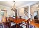 View of dining room with hardwood floors, area rug, chandelier, and open staircase at 7713 Summercrest Dr, Apex, NC 27539