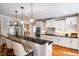 Bright kitchen features an island with seating, stainless steel appliances, and white cabinetry at 7713 Summercrest Dr, Apex, NC 27539