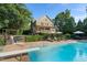 Backyard pool with diving board, hot tub, and lush greenery on a sunny day at 7713 Summercrest Dr, Apex, NC 27539
