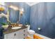 Elegant powder room featuring stylish mirror, fixtures and bold blue walls at 7713 Summercrest Dr, Apex, NC 27539