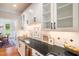 Wet bar featuring black countertop, sink, and storage with glass front cabinets at 7713 Summercrest Dr, Apex, NC 27539