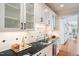 Charming wet bar with black countertops, sink and glass-front cabinets at 7713 Summercrest Dr, Apex, NC 27539