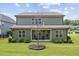 Spacious backyard featuring a large lawn, mature landscaping, and a covered patio area at 824 Stanly House St, Wake Forest, NC 27587