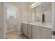 Well-lit bathroom with a double vanity, a large mirror, and ceramic tile flooring at 824 Stanly House St, Wake Forest, NC 27587