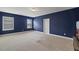Spacious bedroom with modern blue walls, two windows, and neutral carpeting at 824 Stanly House St, Wake Forest, NC 27587