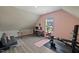 Versatile bonus room featuring a sloped ceiling, pink walls, and space for work and exercise at 824 Stanly House St, Wake Forest, NC 27587