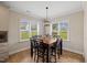 Bright dining area features a wooden table, six chairs, and a large window with neighborhood views at 824 Stanly House St, Wake Forest, NC 27587
