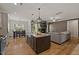 Open-concept kitchen with a large island, granite countertops, and stainless steel appliances flowing into the living area at 824 Stanly House St, Wake Forest, NC 27587