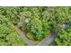 An aerial view of a wooded lot with mature trees and a house nestled among them, providing privacy at 908 Cedar Fork Trl, Chapel Hill, NC 27514