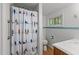 Charming bathroom with white penny tile, a bird-patterned shower curtain and wood vanity at 908 Cedar Fork Trl, Chapel Hill, NC 27514