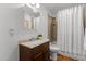 Bathroom featuring a single vanity with a dark wood cabinet, tiled shower, and white shower curtain at 908 Cedar Fork Trl, Chapel Hill, NC 27514