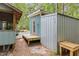 The exterior of an outbuilding with a covered storage area and a small side deck at 908 Cedar Fork Trl, Chapel Hill, NC 27514
