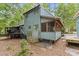 Charming home exterior featuring wood siding, a screened porch, and a deck in a wooded setting at 908 Cedar Fork Trl, Chapel Hill, NC 27514