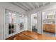 Hallway featuring hardwood floors, French doors to the backyard, and access to a bathroom and kitchen area at 908 Cedar Fork Trl, Chapel Hill, NC 27514
