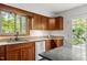 Cozy kitchen featuring wood cabinets, granite countertops, and a stainless steel dishwasher at 908 Cedar Fork Trl, Chapel Hill, NC 27514