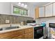 Kitchen featuring light cabinets, tile backsplash, stainless steel sink, and views to the outdoors at 908 Cedar Fork Trl, Chapel Hill, NC 27514