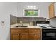 Kitchen featuring light cabinets, tile backsplash, stainless steel sink, and views to the outdoors at 908 Cedar Fork Trl, Chapel Hill, NC 27514