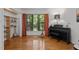 Well-lit music room with hardwood floors, a piano, and natural light from a large window at 908 Cedar Fork Trl, Chapel Hill, NC 27514