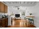 Open living room featuring hardwood floors, exposed beams, a ceiling fan, and a view of the kitchen at 908 Cedar Fork Trl, Chapel Hill, NC 27514
