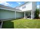 View of grassy backyard with the home's exterior, featuring a covered porch and well-kept lawn at 979 Branch Line Ln, Apex, NC 27502