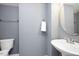 Neutral-toned half bathroom with a pedestal sink and an oval mirror at 979 Branch Line Ln, Apex, NC 27502