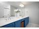 Bathroom featuring double sink vanity with blue cabinets, and a large mirror at 979 Branch Line Ln, Apex, NC 27502