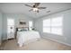 Bedroom features large windows, neutral carpet, a ceiling fan, and a queen bed at 979 Branch Line Ln, Apex, NC 27502