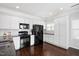 Modern kitchen with white cabinets, black appliances, granite countertops, and subway tile backsplash at 979 Branch Line Ln, Apex, NC 27502