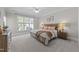 Bright bedroom featuring a ceiling fan, a large window, and carpeted floors at 103 Aisling Ct, Cary, NC 27513