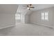 Bright bonus room featuring carpet, a ceiling fan, windows, and unique architectural details at 103 Aisling Ct, Cary, NC 27513